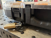 Close-up of the locking mechanism on the custom mounting plate, now featuring a padlock securing the mechanism with a workshop in the background.DeWalt ToughSystem 2.0 wall mount plate side view showing powder-coated 10-gauge steel finish