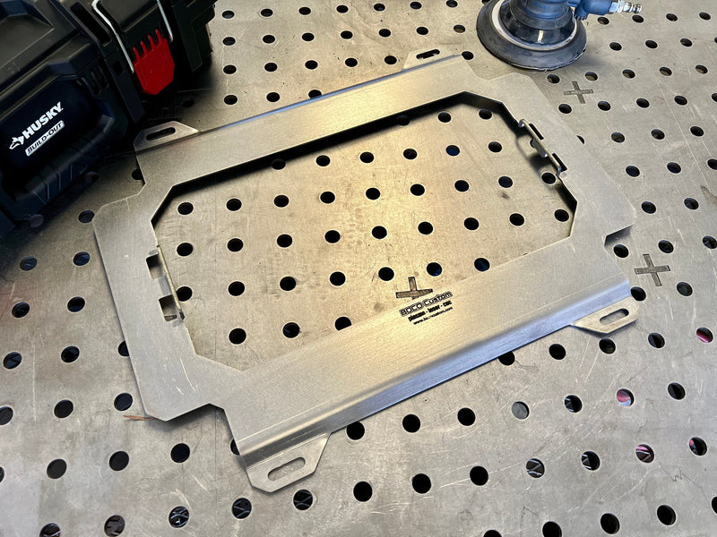 Metal pegboard tray on a perforated metal surface with a Husky tool in the background