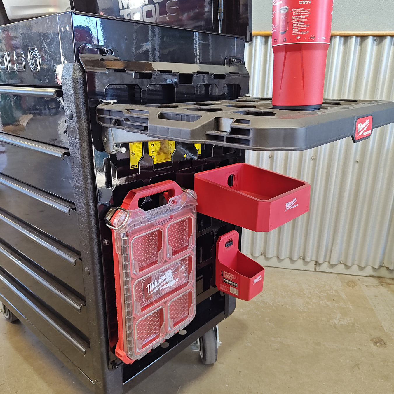 Heavy-duty laser-cut steel mounting plate attached to the side of a red Matco toolbox, featuring a modular Milwaukee Packout-compatible interface for shop organization.