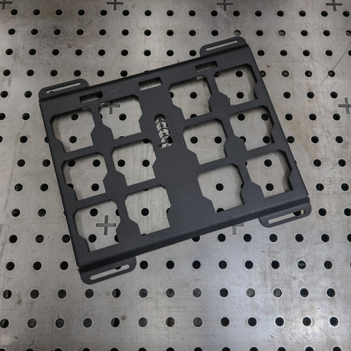Black powder-coated Milwaukee Packout steel mounting plate on a professional welding table—heavy-duty 10-gauge alternative to Milwaukee 48-22-8485 for custom shop builds.