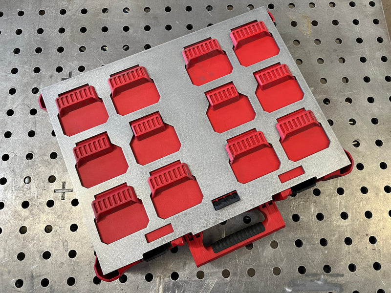 Red silicone mold on a gray tray against a pegboard background