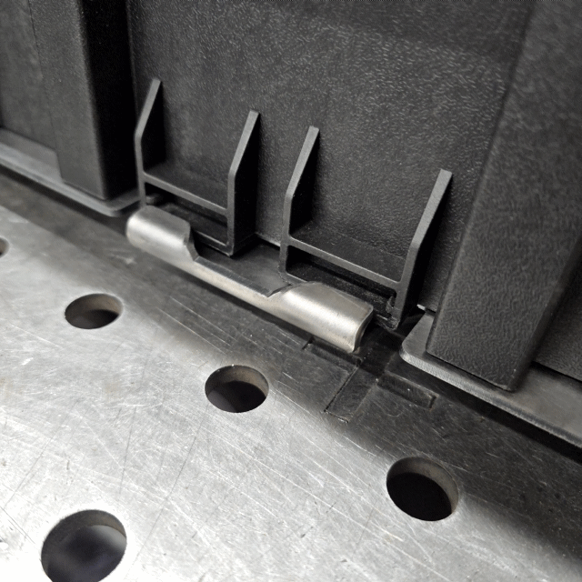 Close-up animation showing the steel locking arm securely latching and snapping onto a Bauer modular toolbox.