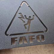 Close-up of imperfect plasma cut FAFO graphic with rough edges on black powder coat plate